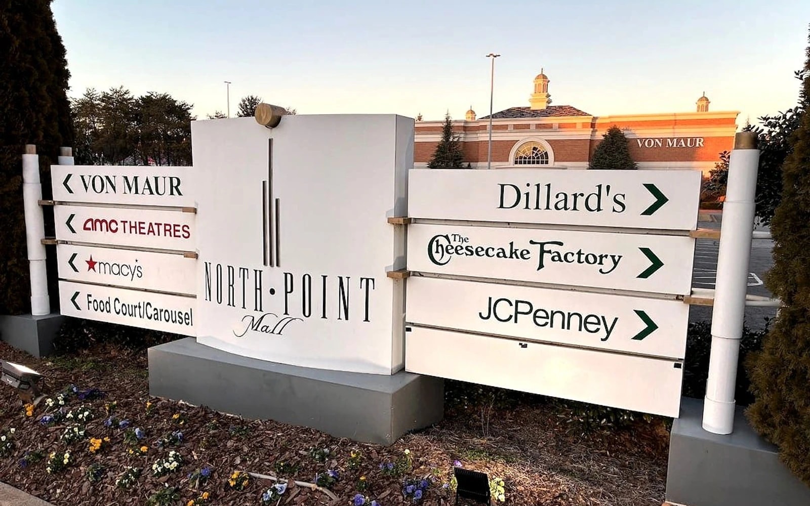 North Point Mall sign directs visitors to stores and theaters in front of the Von Maur building at dusk.