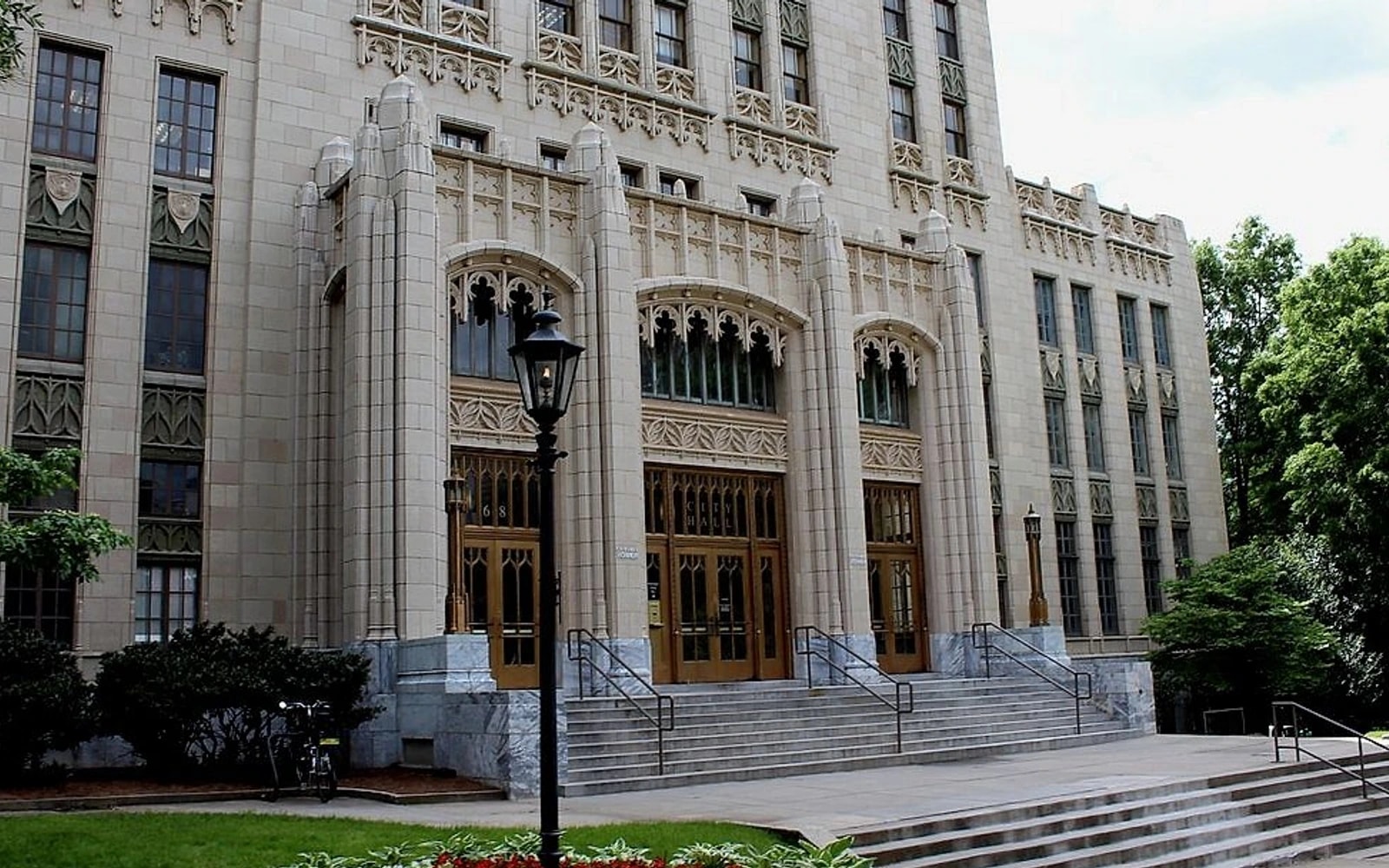The ornate stone entrance and steps of Atlanta City Hall, framed by trees and a black streetlamp.