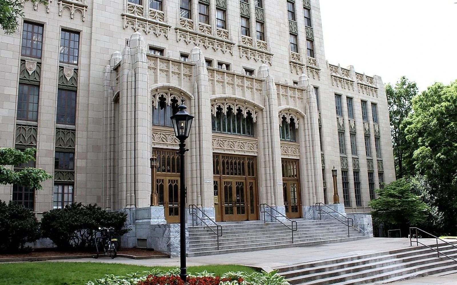 The ornate stone entrance and steps of Atlanta City Hall, with a black lamppost in front.