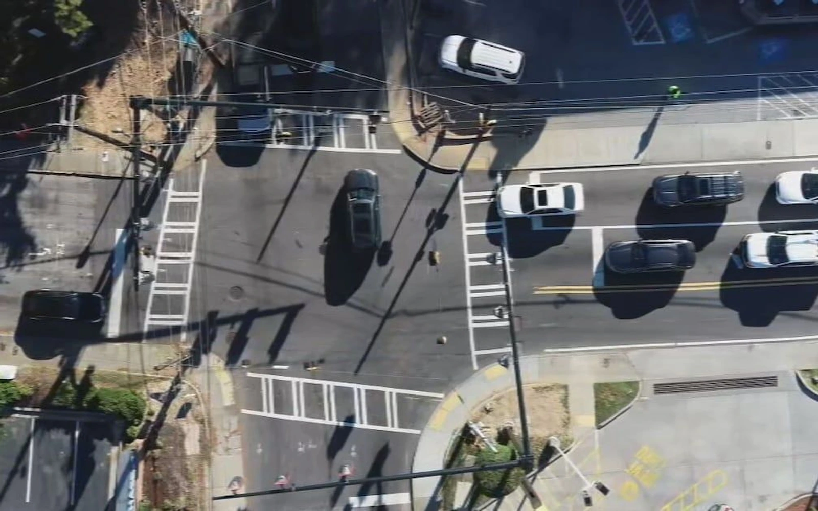 Overhead view of an Atlanta intersection with striped crosswalks, several cars, sidewalks and curb corners.